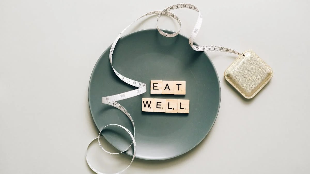 Flat lay of scrabble tiles spelling 'eat well' on a plate with a tape measure, promoting healthy eating.